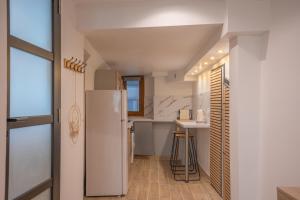 a kitchen with a white refrigerator and a sink at La vie en rose in Grasse