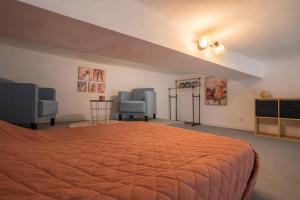 a bedroom with a large bed and two chairs at La vie en rose in Grasse +19 photos