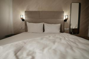 a large white bed with two pillows and a mirror at Atri's Boutique in Aiud