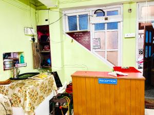 a room with a table and a window and a staircase at PEMA Hotel VSTM in Darjeeling