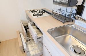 a kitchen with a sink and a stove at muniyuitsu 宮古島 spa&park in Miyako-jima +23 photos