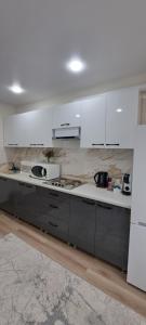 a kitchen with white cabinets and a counter top at MyApartment in Chişinău
