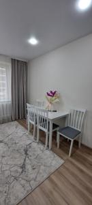 a white dining room with a white table and chairs at MyApartment in Chişinău +8 photos