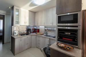 a kitchen with white cabinets and a sink and an oven at Seaside Apartment with a great view in Chalkida in Chalkida +13 photos