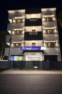 a building with a sign on the side of it at Naadi Grand Inn in Thanjāvūr