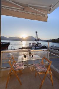 a balcony with two chairs and a table and a boat at Seaside Apartment with a great view in Chalkida in Chalkida