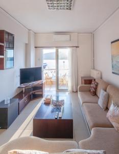 a living room with a couch and a tv at Seaside Apartment with a great view in Chalkida in Chalkida
