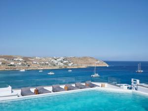 ein Pool mit Liegestühlen und Meerblick in der Unterkunft Pietra e Mare - Mykonos Moments by Mr and Mrs White in Kalo Livadi