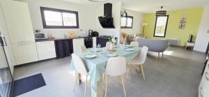a dining room with a blue table and chairs at Fleur Du Ciel Vendée in Challans
