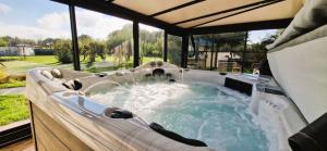 a jacuzzi tub in a room with windows at Fleur Du Ciel Vendée in Challans