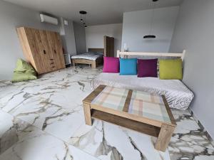 a room with a bed and a table on a marble floor at Apartament Sosnowy Las Widok na morze in Rowy