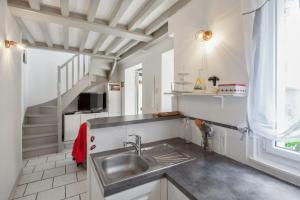 a kitchen with a sink and a staircase at Maison charmante près de Sainte Catherine in Honfleur