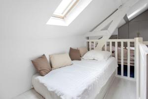 a white couch in a room with a staircase at Maison charmante près de Sainte Catherine in Honfleur