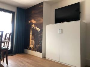 a living room with a white cabinet with a tv on it at Landhaus Osttirol in Iselsberg