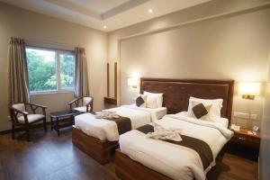 a hotel room with two beds and a window at Neel Clarks Inn Express in Agra +86 photos