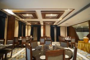 a restaurant with tables and chairs in a room at Neel Clarks Inn Express in Agra