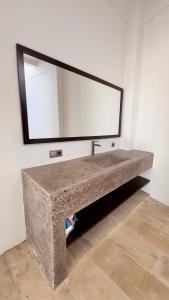 a stone sink in a room with a mirror at Tris Villa 3 in Bumbang