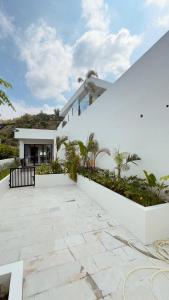 a white house with a courtyard with palm trees at Tris Villa 3 in Bumbang