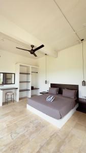 a bedroom with a large bed and a ceiling fan at Tris Villa 3 in Bumbang