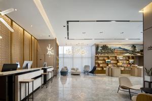 a lobby with a reception desk and chairs at Atour Hotel Hefei Changjiang Road Zhixincheng Annongda in Hefei