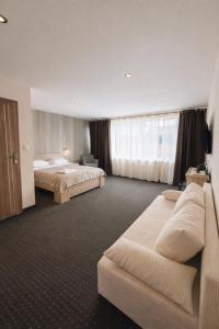 a hotel room with a bed and a couch at Willa Alexia in Kudowa-Zdrój