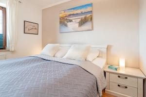 a bedroom with a bed and a table with a night stand at Strandburg Ostseeblick Scharbeutz in Scharbeutz