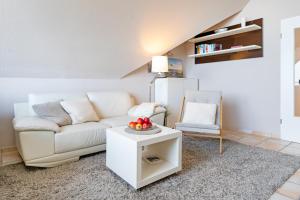 a living room with a white couch and a table at Strandburg Ostseeblick Scharbeutz in Scharbeutz
