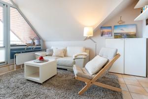 a living room with a couch and a chair at Strandburg Ostseeblick Scharbeutz in Scharbeutz