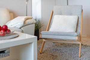 a chair in a living room next to a couch at Strandburg Ostseeblick Scharbeutz in Scharbeutz +31 photos