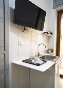 a kitchen with a sink and a flat screen tv at B&B dalla Nonna in Salerno +11 photos