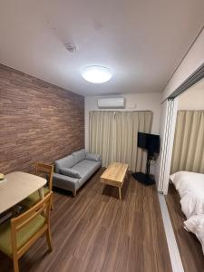 ein Zimmer mit einem Bett, einer Couch und einem Tisch in der Unterkunft casa de sol in Miyakojima + 6 Fotos