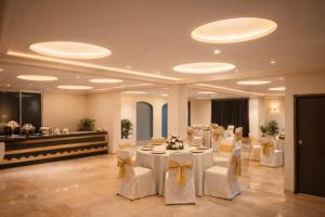 a banquet hall with white tables and white chairs at Hotel Nomadic in Udaipur
