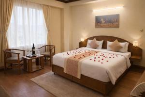 a bedroom with a large bed with roses on it at Hotel Rana Taradevi in Shimla +17 photos