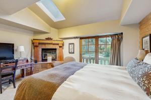 a bedroom with a bed and a desk and a television at Hotel studio with views fireplace & close to everything in Park City