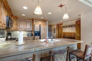 a kitchen with wooden cabinets and a large counter top at Epic view condo with fireplaces & close to everything in Park City