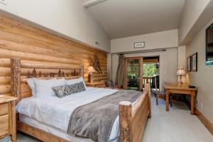 a bedroom with a bed and a wooden wall at Epic view condo with fireplaces & close to everything in Park City