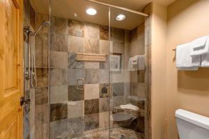a bathroom with a shower with a glass door at Epic view condo with fireplaces & close to everything in Park City +17 photos