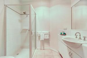 a white bathroom with a shower and a sink at Seymours On Lydiard in Ballarat +39 photos