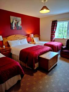 a hotel room with two beds and a chair at Lake Avenue House in Ballyconnell