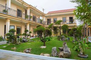 a garden in front of a building with rocks and trees at Sunset Garden in Phúc Trì