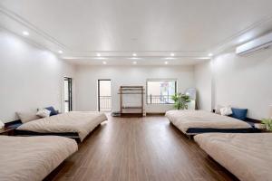 a large room with three beds in it at Sunset Garden in Phúc Trì