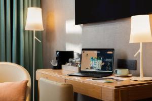 a laptop computer sitting on a desk with two lamps at Hôbou - ex Hotel Acanthe in Boulogne-Billancourt