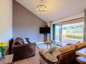 a living room with leather furniture and a large window at 2 Bed in Bridgnorth oc-77721 in Highley