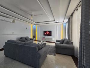 a living room with two couches and a tv at Impala Villas in Mombasa
