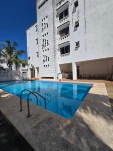 a swimming pool in front of a building at Impala Villas in Mombasa