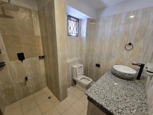 a bathroom with a sink and a toilet at Impala Villas in Mombasa +4 photos
