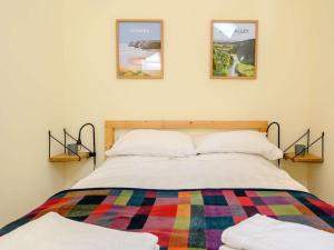 a bedroom with a bed with three pictures on the wall at 1 Bed in Clyro oc-86975 in Clyro