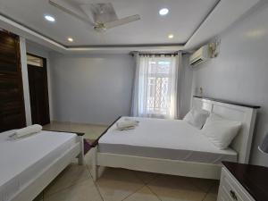 a bedroom with two beds and a window at Impala Villas in Mombasa