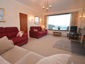 a living room with red furniture and a large window at 2 Bed in Bideford oc-sandb in Instow
