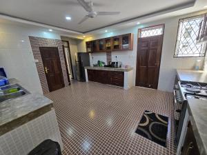 a large kitchen with a sink and a stove at Impala Villas in Mombasa
